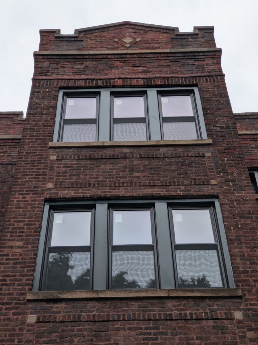Black replacement window sets installed in a brick building