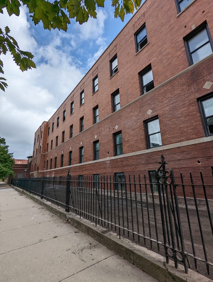 Large brick building window replacement project with black frames