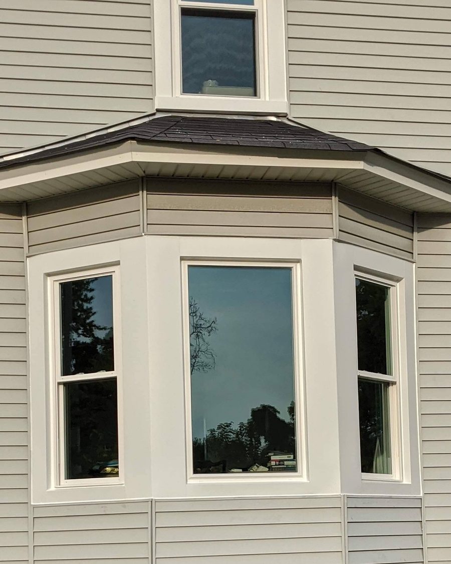 White bay window replacement close-up on siding exterior